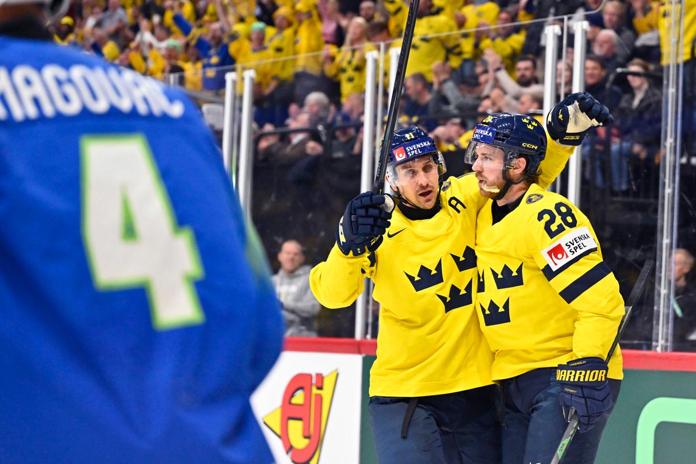 Elias Lindholm (28) firar ett av sina mål tillsammans med Mikael Backlund. Foto: Anders Wiklund/TT