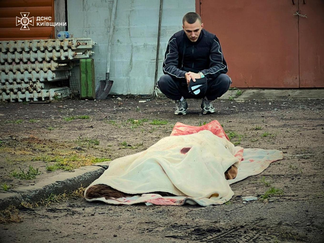En filt täcker en kvinna som dödats i ryska drönaranfall mot Kiev tidigt på söndagen. Foto: Ukrainas räddningstjänst via AP/TT