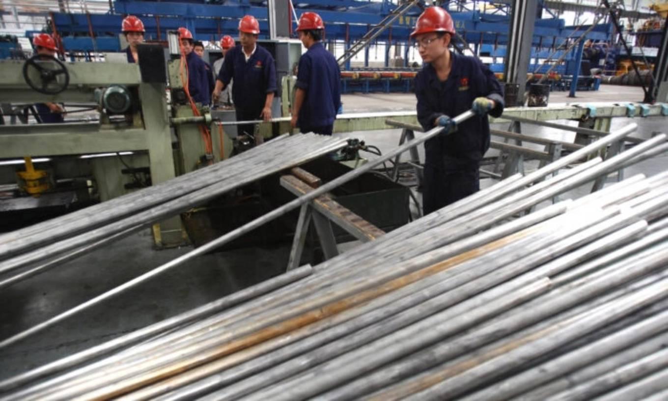 En arbetare flyttar aluminiumrör på Qinghai Guoxin Aluminium Industry Incorporated Company i Xining, Qinghai-provinsen i Kina. Foto: Feng Li/Getty Images