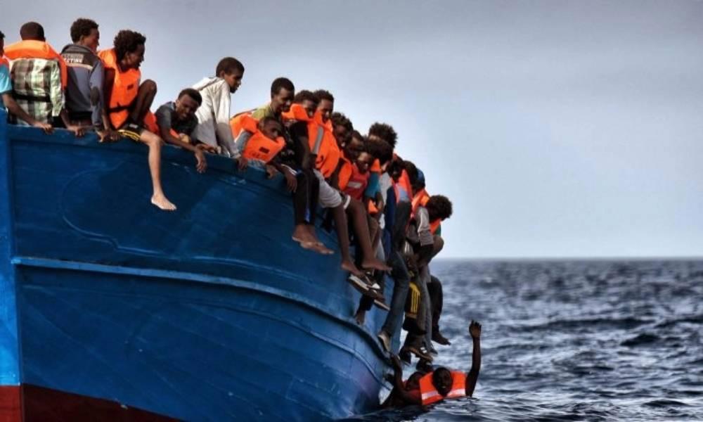 Migranter hänger från en båt i väntan på att bli räddade när de driver omkring i Medelhavet cirka 20 sjömil norr om Libyens kust den 3 oktober 2016. Foto: Aris Messinis/AFP/Getty Images