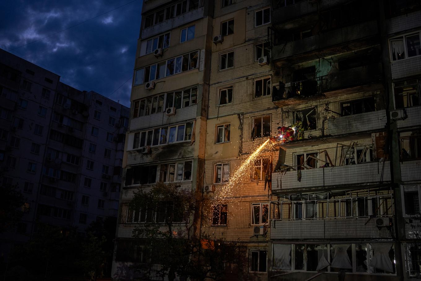 En brandman arbetar på ett höghus i Kiev efter att det träffats av en rysk projektil under natten till lördag. Foto: Alex Babenko/AP/TT
