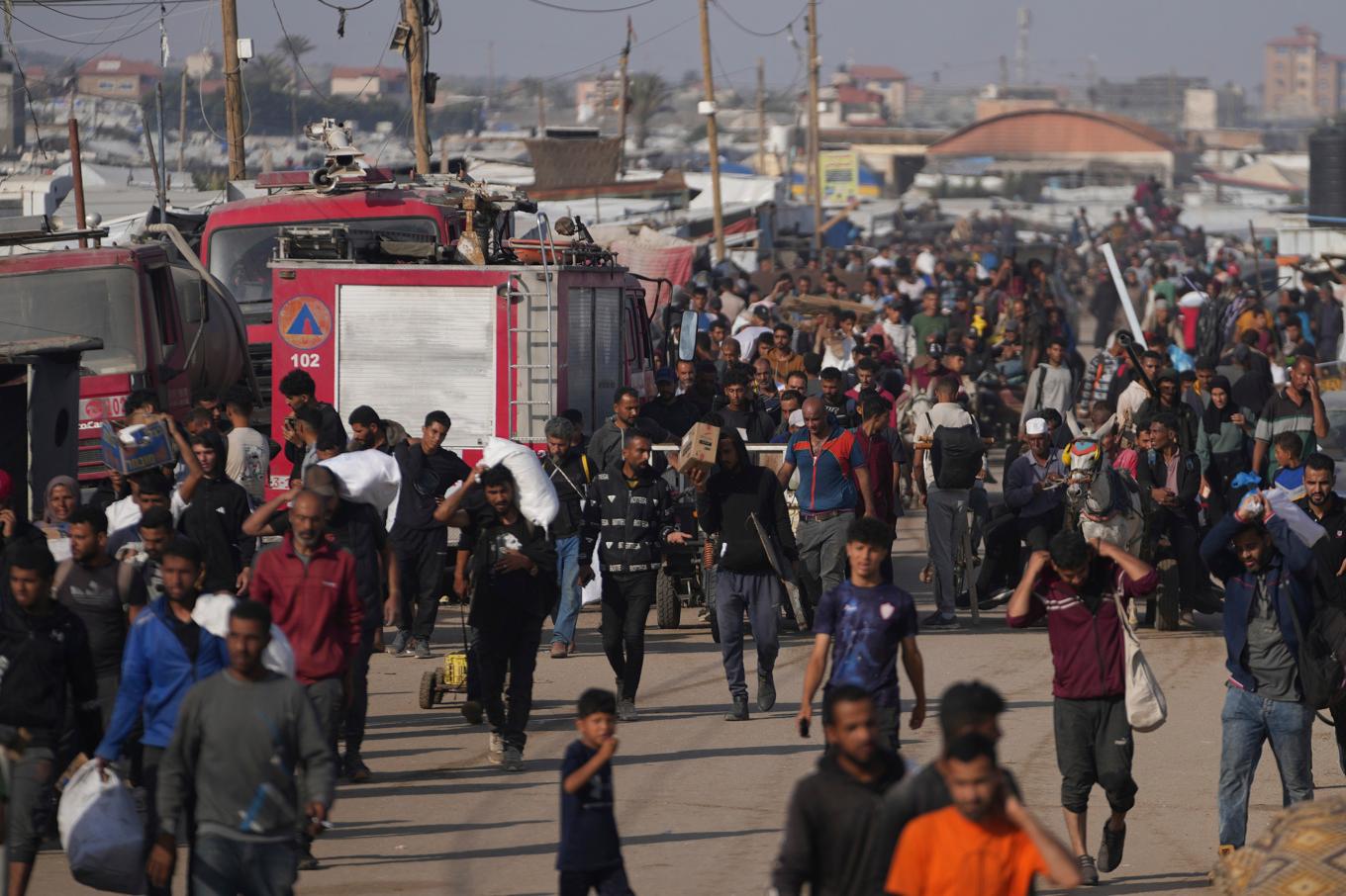 Palestinier bär på nödhjälp från det kontroversiella initiativet Gaza Humanitarian Foundation (GHF). Bilden togs i söndags i Khan Yunis i Gaza. Foto: Abdel Kareem Hana/AP/TT