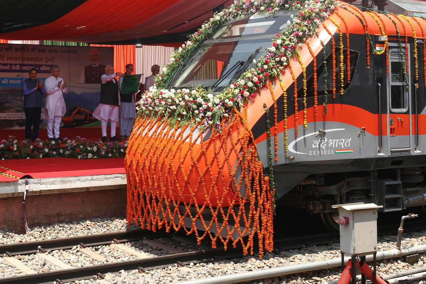 Tåget Vande Bharat Express i Srinagar i Indienkontrollerade Kashmir på fredagen. Premiärminister Narendra Modi står på plattformen med en flagga i handen. Foto: AP/TT