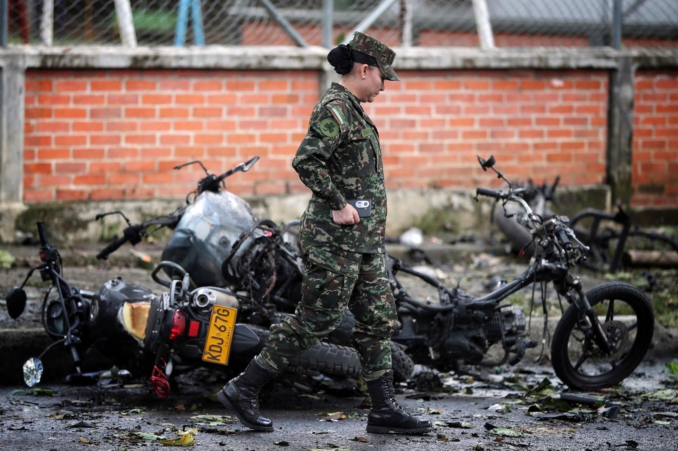 En soldat går förbi en utbränd motorcykel sedan en bomb exploderat i staden Cali i Colombia. Foto: Santiago Saldarriaga/AP/TT