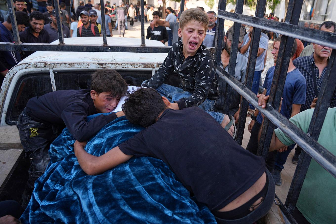 Tre barn sörjer sin pappa, Mohammed Ghaben, som dödats vid en matutdelning i Gaza på onsdagen. Foto: Jehad Alshrafi/AP/TT