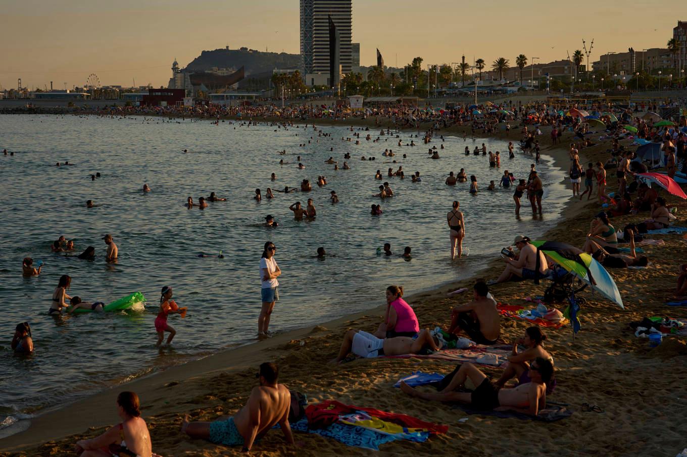Människor passar på att svalka sig i ett varmt Barcelona under söndagen. Foto: Emilio Morenatti/AP/TT