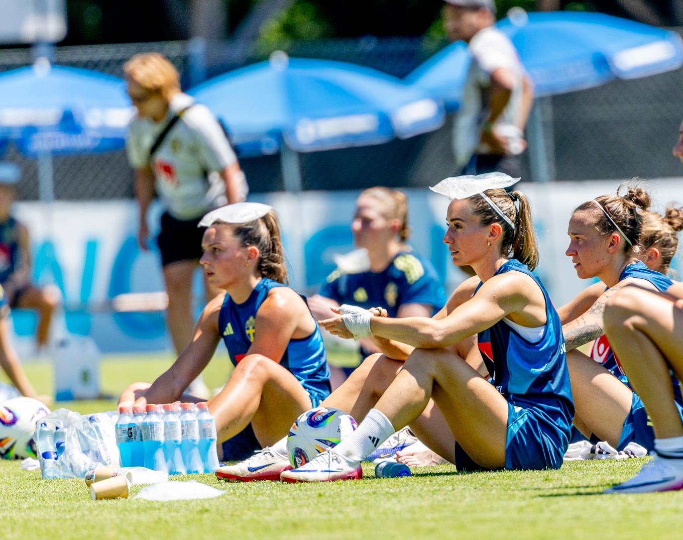 Svenskorna Kosovare Asllani och Johanna Rytting Kaneryd svalkar sig i värmen under första träningen i Schweiz. Foto: Adam Ihse/TT