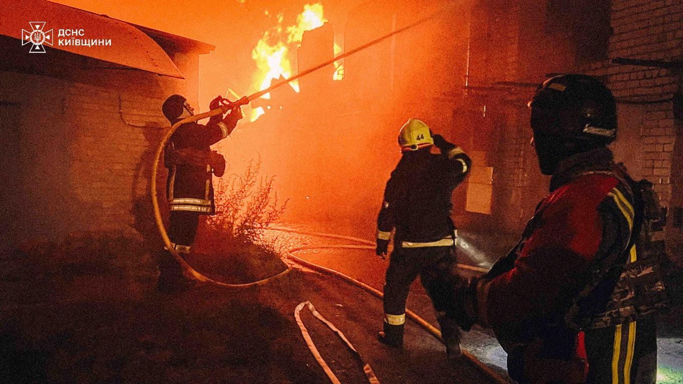 Brandmän jobbar med att släcka bränder strax sydväst utanför huvudstaden efter nattens ryska attacker. Foto: Ukrainas statliga räddningstjänst via AP/TT