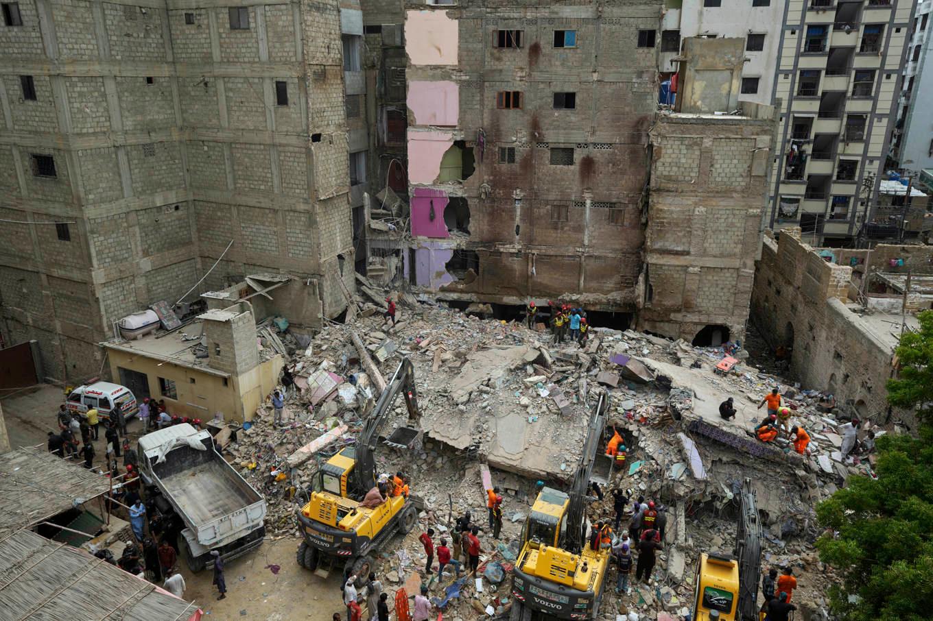 Räddningsarbetare röjer upp efter fredagens ras i Karachi, Pakistan. Foto: Fareed Khan/AP/TT