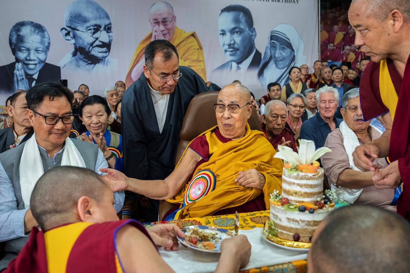 Dalai lama firar sin 90-årsdag omgiven av sina anhängare, däribland filmstjärnan Richard Gere i mörk skjorta. Foto: Tenzin Choejor/AP/TT