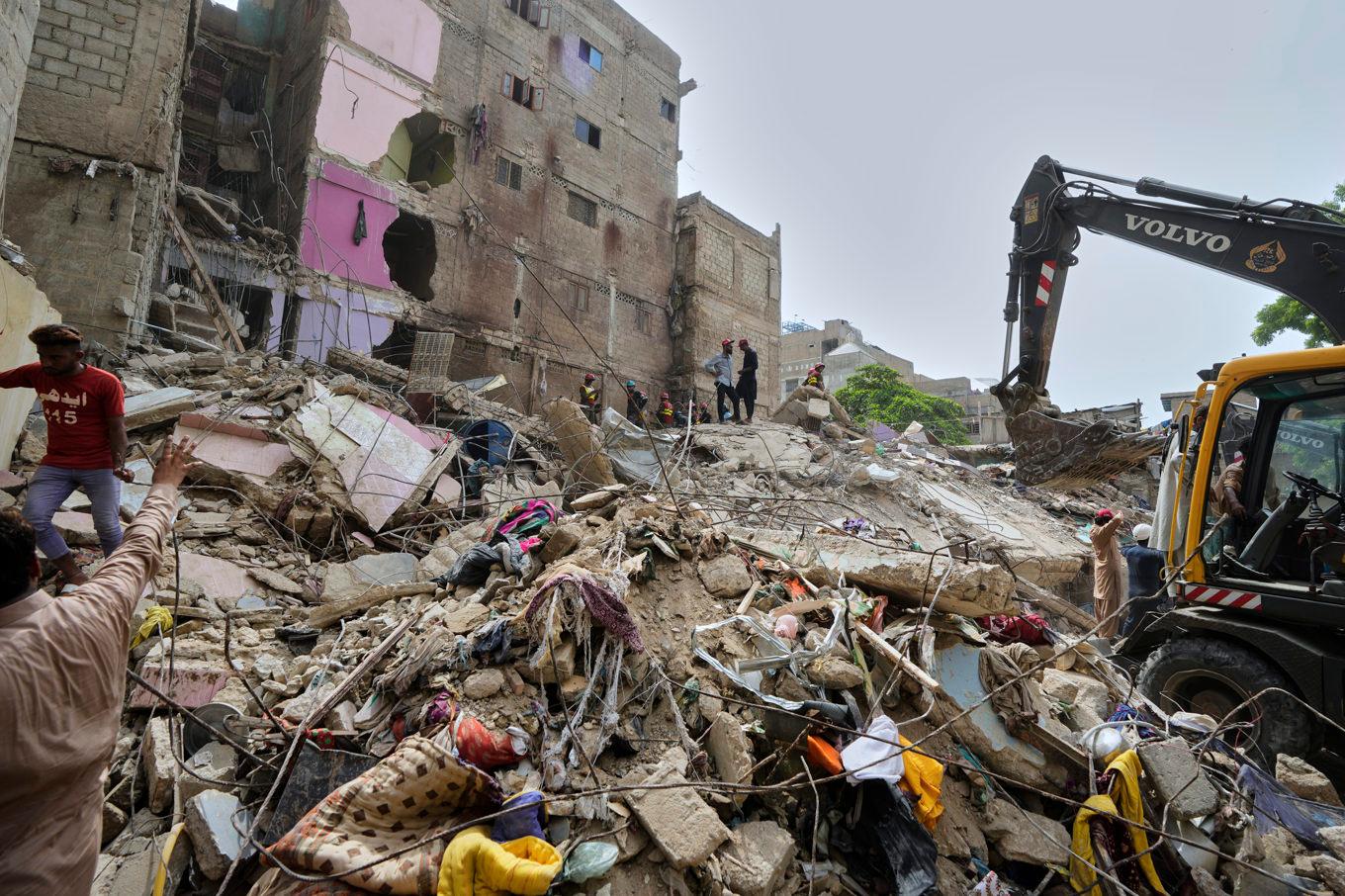 Räddningsmanskap söker igenom resterna av ett kollapsat hus i Karachi i Pakistan. Foto: Fareed Khan/AP/TT
