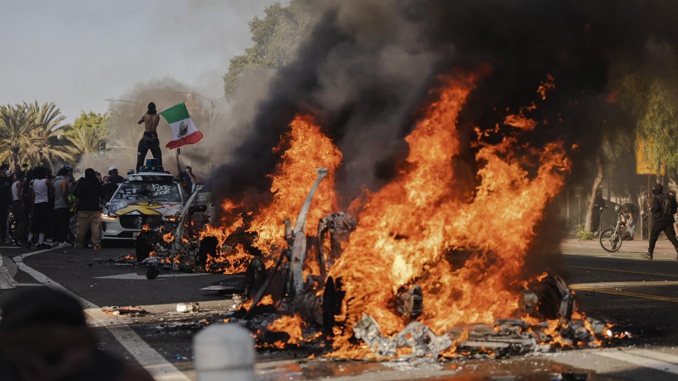 Flera bilar brinner på en gata i centrala Los Angeles den 8 juni. Foto: Jim Vondruska/Getty Images