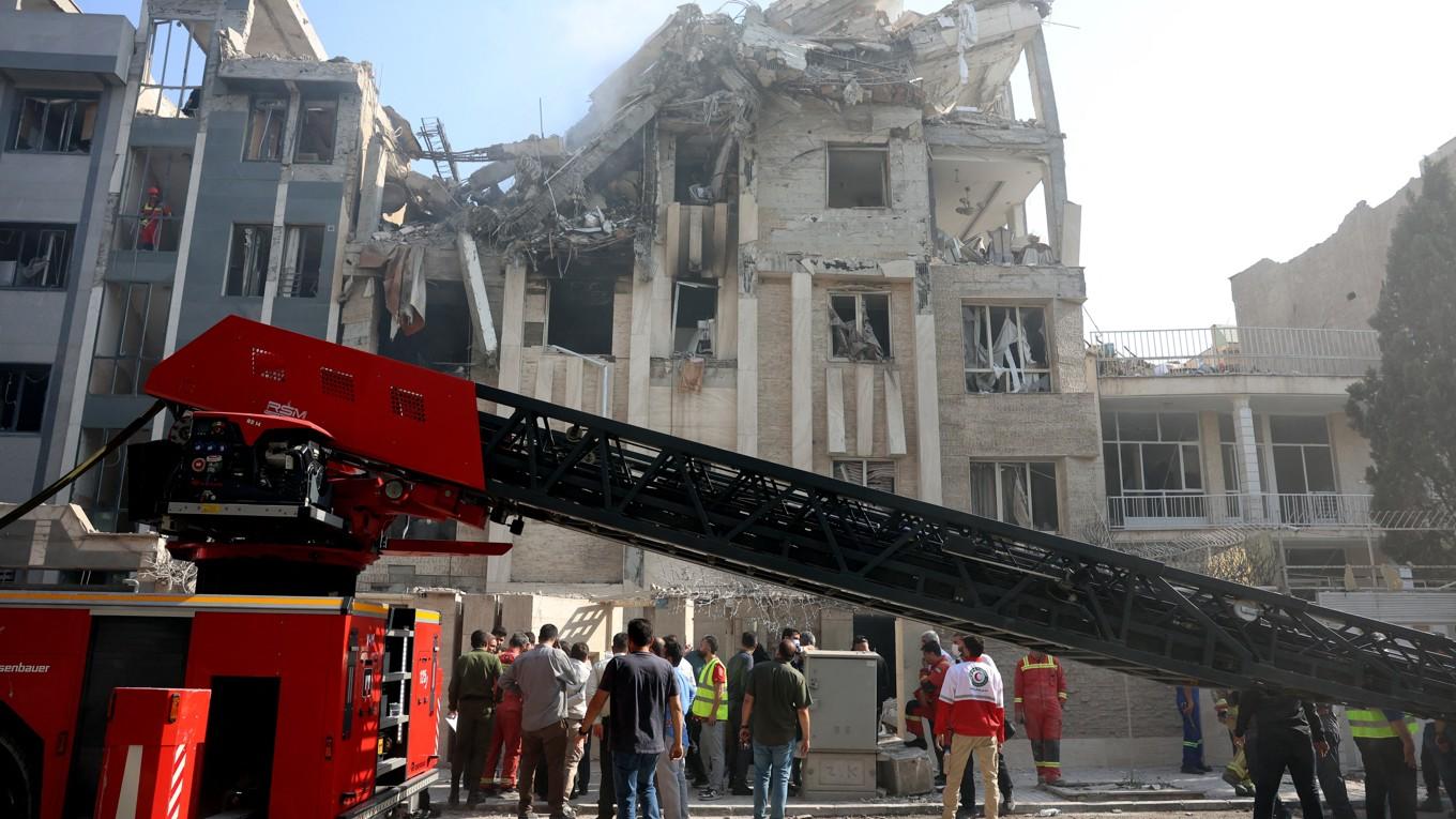 Räddningspersonal arbetar utanför en svårt skadad byggnad som träffats av en israelisk attack i den iranska huvudstaden Teheran den 13 juni. Foto: AFP via Getty Images