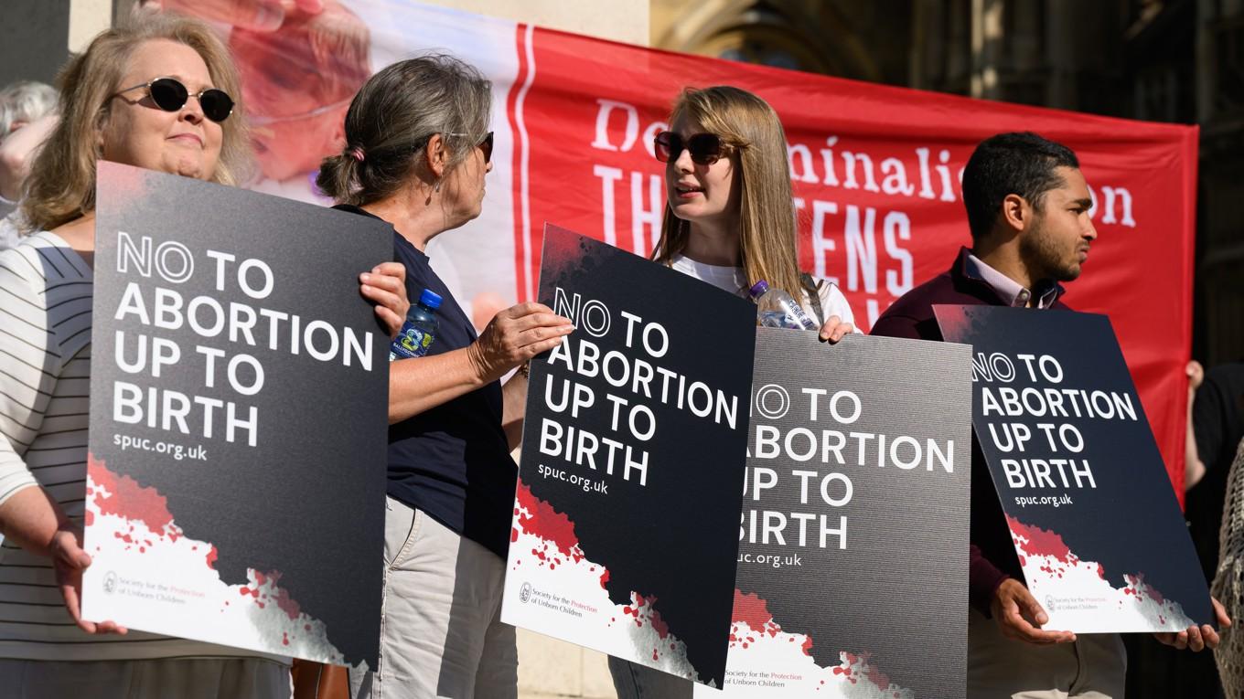 Personer som ingår i gruppen ”The Society for the Protection of Unborn Children” (SPUC) protesterar mot förslaget om avkriminalisering av abort utanför parlamentet den 17 juni i London. Foto: Leon Neal/Getty Images