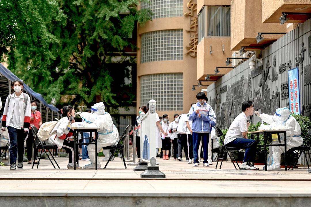 Hälso- och sjukvårdspersonal testar en elev för covid-19 i Peking den 7 juni 2022. Foto: Jade Gao/AFP via Getty Images