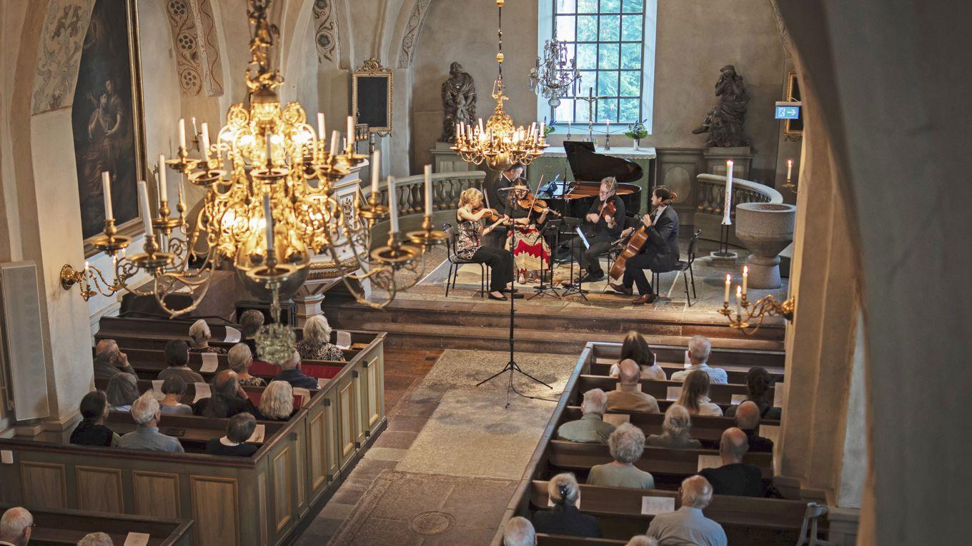 Martin Sturfält och Askanäs stråkensemble under framförandet av Robert Schumanns pianokvintett i Ekerö kyrka. Foto: Willem Stam