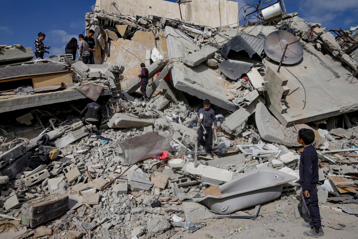 Palestinier undersöker ruinerna av sitt hem i Rafah på Gazaremsan efter det att det bombats av Israel. Bilden är från i januari. Foto: Jehad Alshrafi/AP/TT