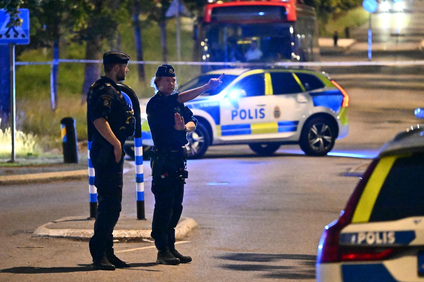 Polis på plats i Vårby i Huddinge söder om Stockholm efter att en man skjutits på fredagskvällen. Foto: Anders Wiklund/TT