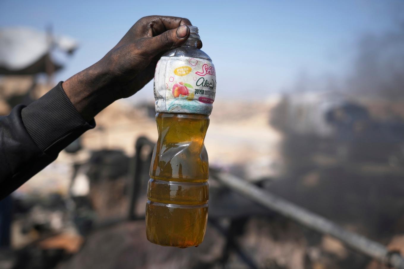 En flaska med hemmagjort bränsle, tillverkat av smält plast, till salu i Gaza. Foto: Abdel Kareem Hana/AP/TT