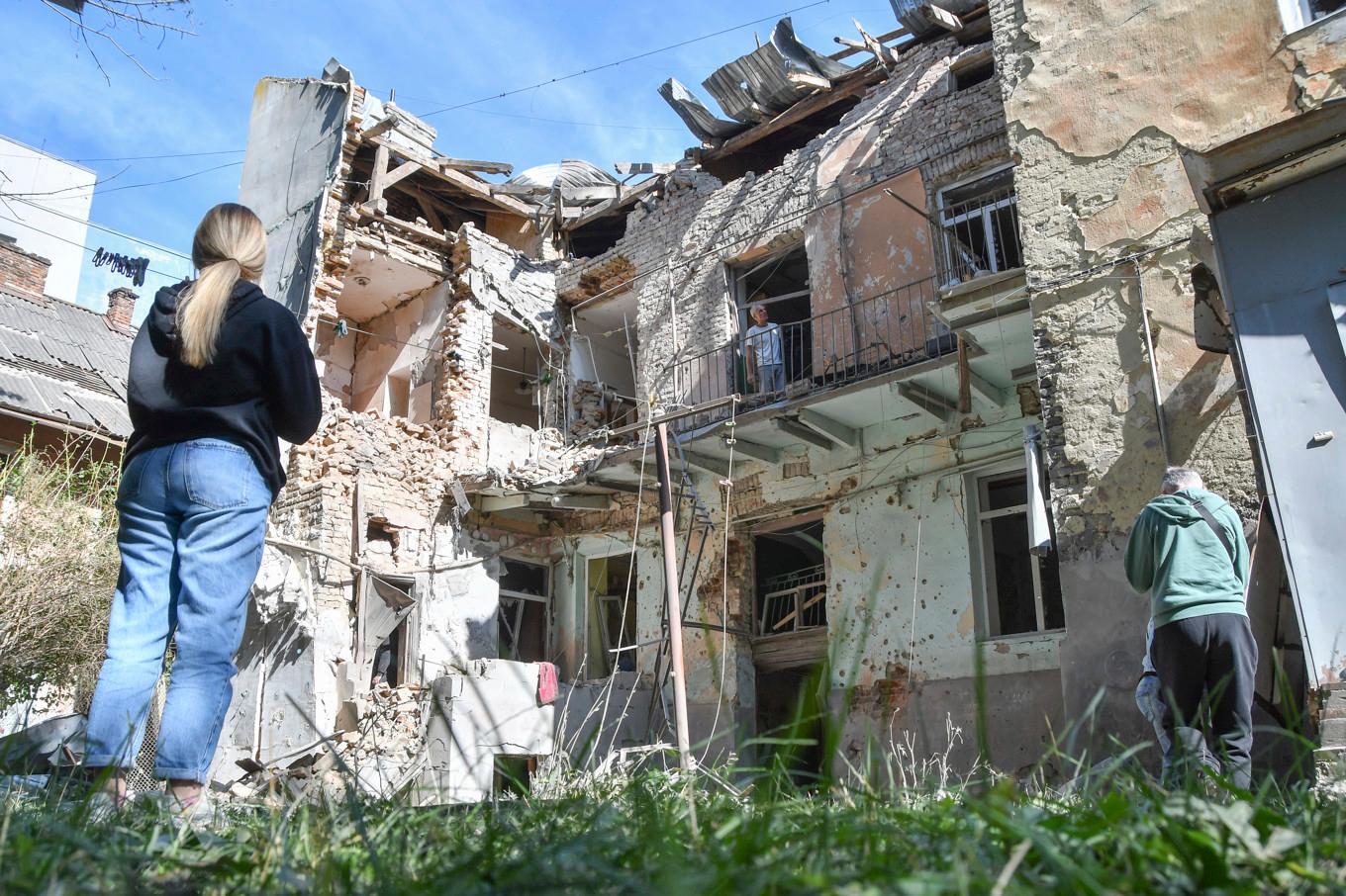 Människor tittar på ett hus som träffats i en rysk attack i staden Lviv i västra Ukraina. Foto: Mykola Tys/AP/TT