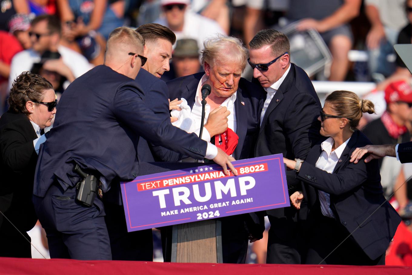Republikanernas presidentkandidat Donald Trump får hjälp att ta sig ner från scenen efter mordförsöket i Butler den 13 juli 2024. Foto: Gene J. Puskar/AP/TT