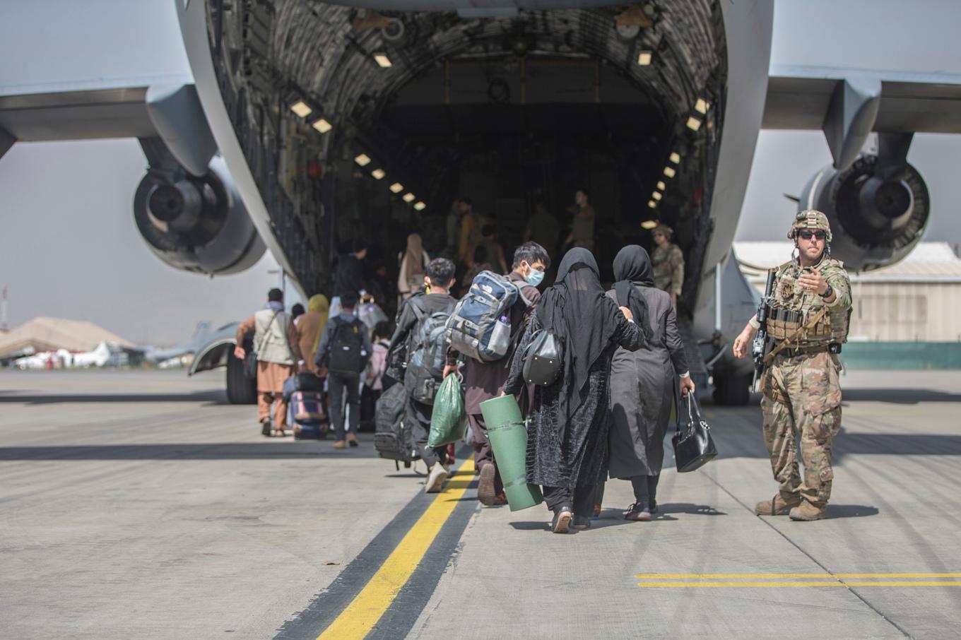 Familjer går ombord på ett amerikanskt militärflygplan i samband med evakueringen av Kabul efter talibanernas maktövertagande 2021. Foto: Samuel Ruiz/AP/TT