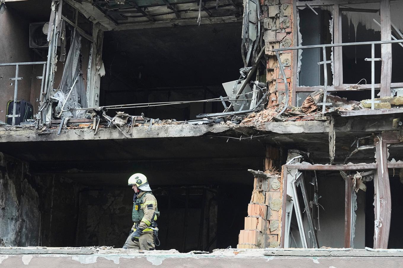 Brandmän arbetar i en byggnad som förstörts efter en rysk attack mot Ukrainas huvudstad Kiev. Foto: Efrem Lukatsky/AP/TT