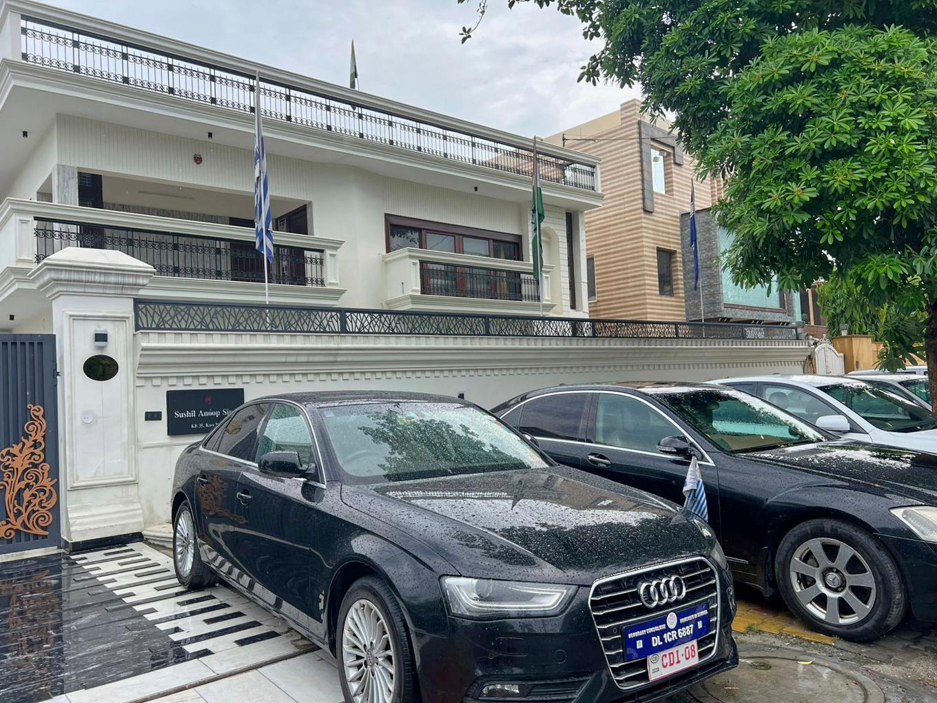 Bilar med falska diplomatiska registreringsskyltar parkerade utanför det hyreshus i Ghaziabad utanför New Delhi där polis misstänker att en 47-årig man legat bakom ett avancerat bedrägeri med en falsk ambassad. Bild från måndag 21 juli. Foto: Polisen i Uttar Pradesh via AP/TT