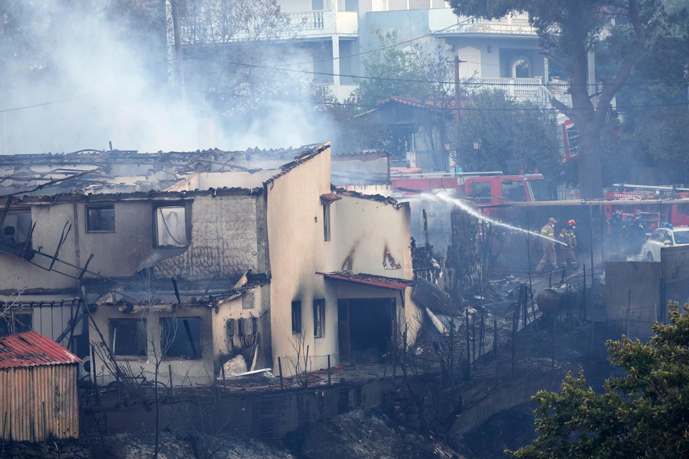 Brandmän försöker rädda ett hus i en förort till Aten. Foto: Yorgos Karahalis/AP/TT