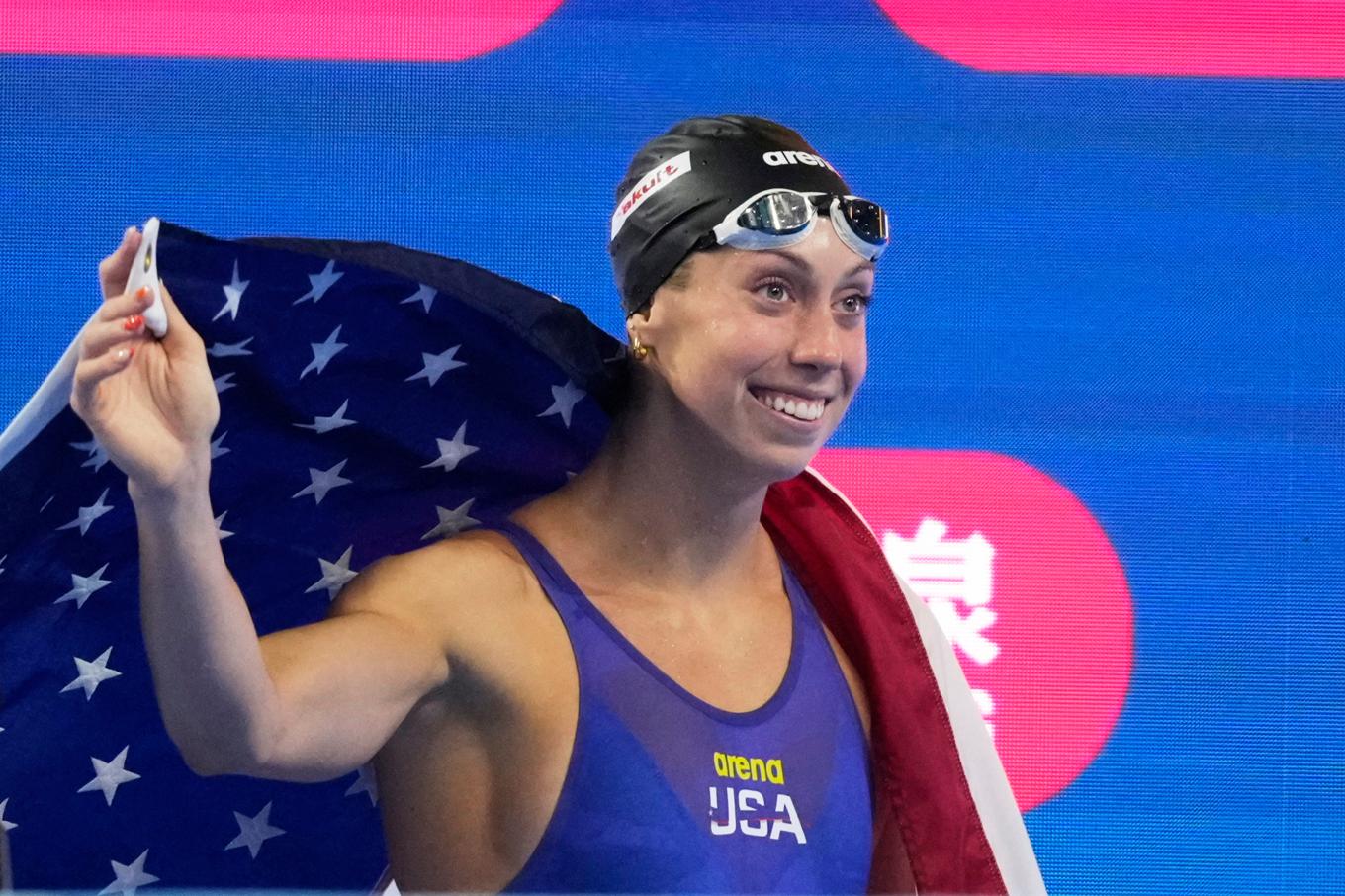 Gretchen Walsh firar, draperad i amerikanska flaggan. Foto: Vincent Thian/AP/TT