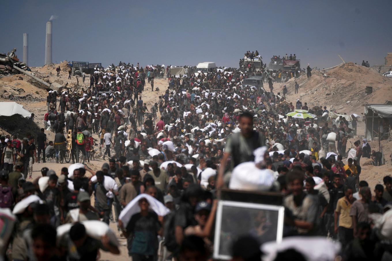 Palestinier som bär på förnödenheter som levererades på fredagen. Foto: Jehad Alshrafi/AP/TT