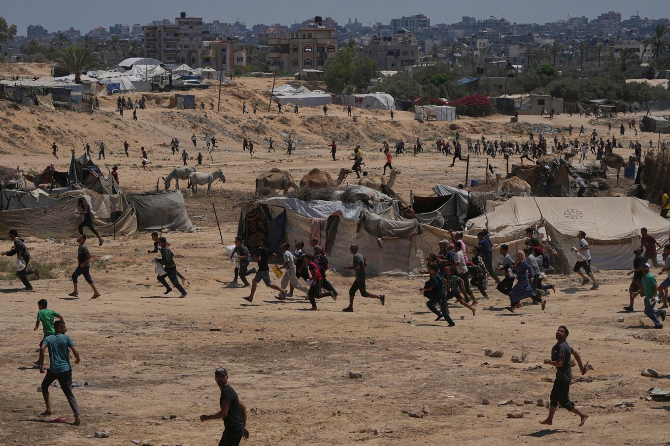Palestiner skyndar för att samla proviant från hjälpsändningar som släppts från luften in i centrala Gaza. Foto: Abdel Kareem Hana/AP/TT