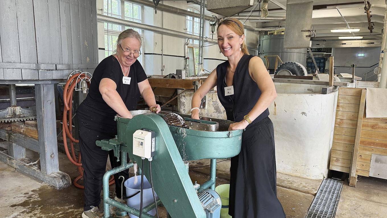 Guiderna Christina Gutiérrez Malmbom och Astrid Raabe håller workshops i papperstillverkning. Här maler de bomullstyg till pappersmassa i den lilla holländaren. Foto: Anton Anderberg