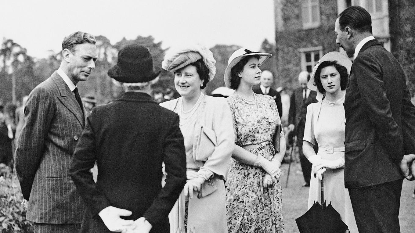 Kung George VI, drottning Elizabeth och prinsessorna Elizabeth och Margaret Rose minglar med gäster den 13 juli 1946. Foto: AP/TT BILD