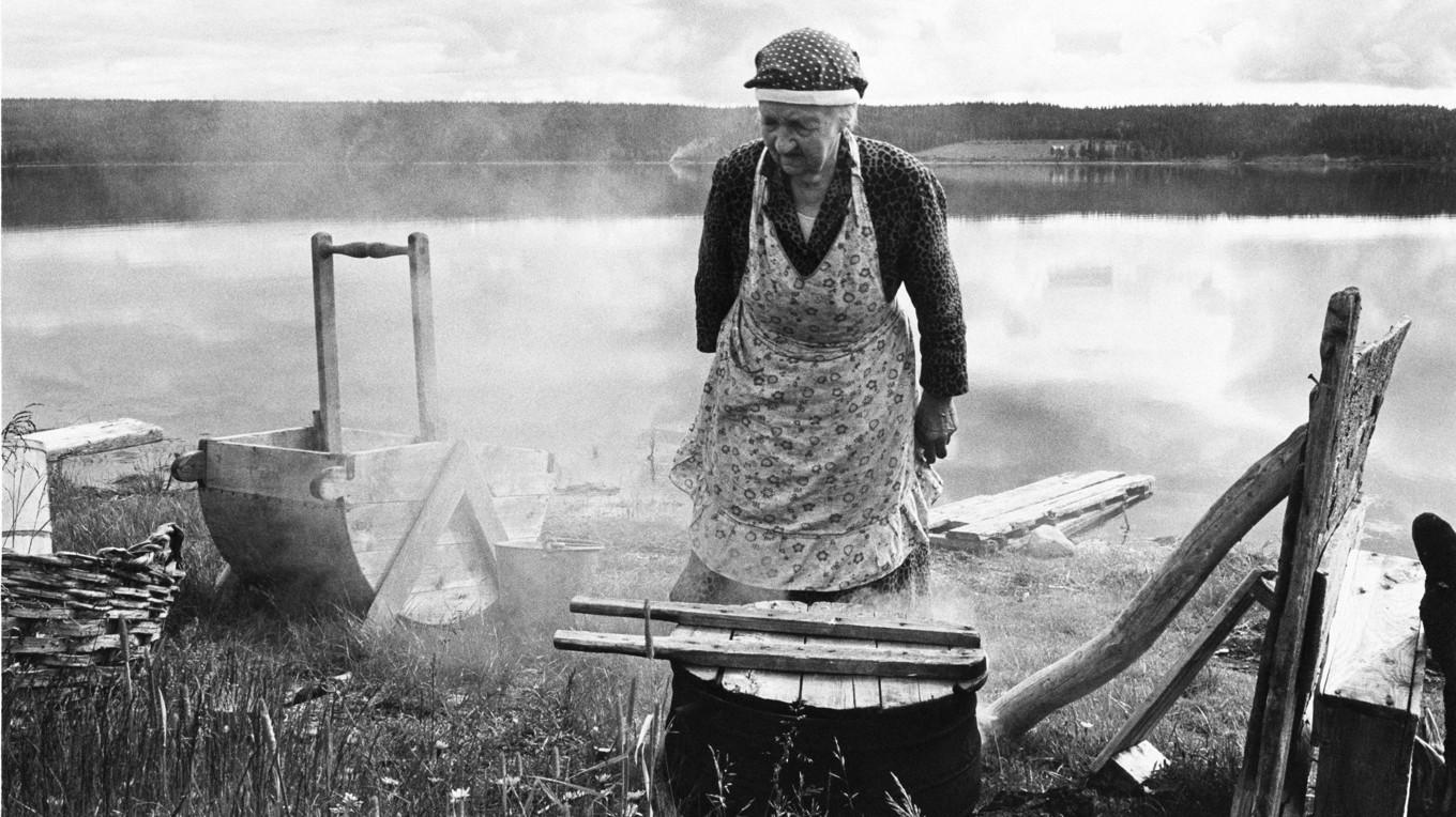 Sune Jonsson fotograferade änkan Lovisa Ahlenius när hon tvättade vid sjön i Norra Tresund i Vilhelmina 1961. Han skildrade människors vardag och ett samhälle i förändring. Foto: Sune Jonsson