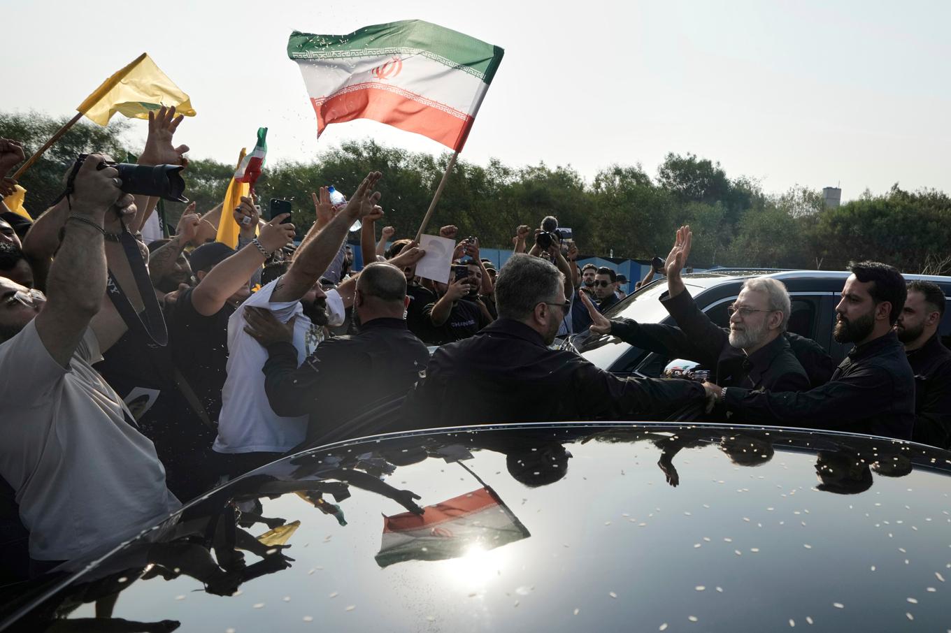 Irans säkerhetschef Ali Larijani, till höger, vinkar mot Hizbollahanhängare vid flytplatsen i Beirut. Foto: Bilal Hussein/AP/TT