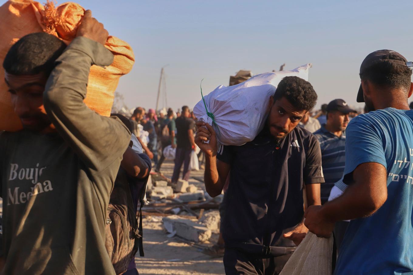 Palestinier i närheten av Rafah bär på nödhjälp. Bilden är tagen 4 augusti. Foto: Mariam Dagga/AP/TT