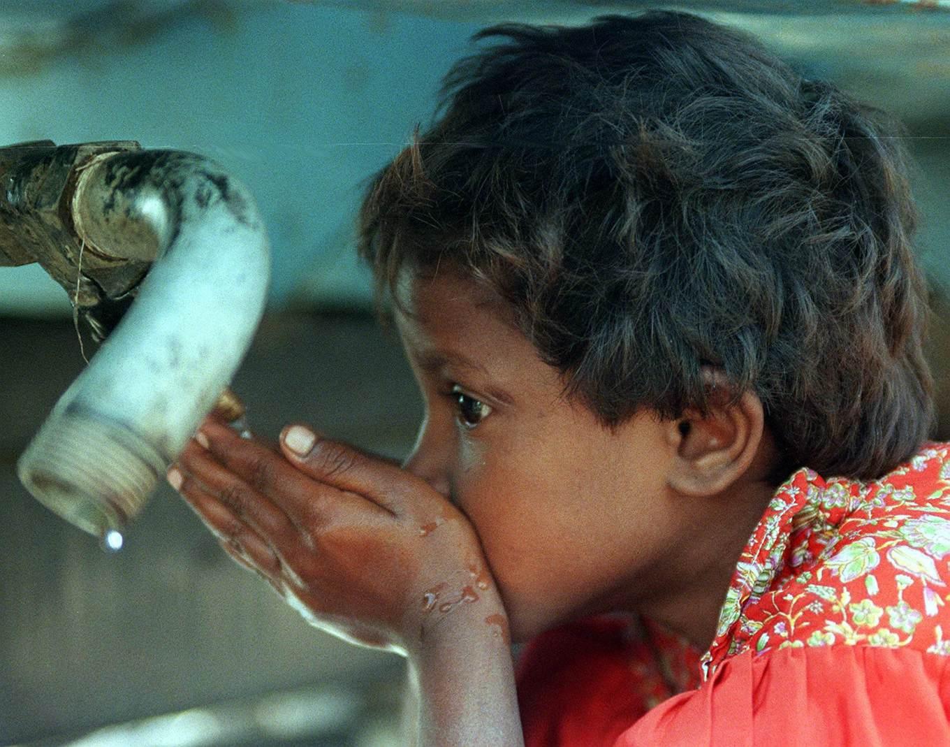 En pojke i New Dehli-området i Indien dricker vatten. Enligt rapporten från FN står var fjärde människa på jorden utan säker tillgång till vatten. Foto: Ajit Kumar/AP/TT