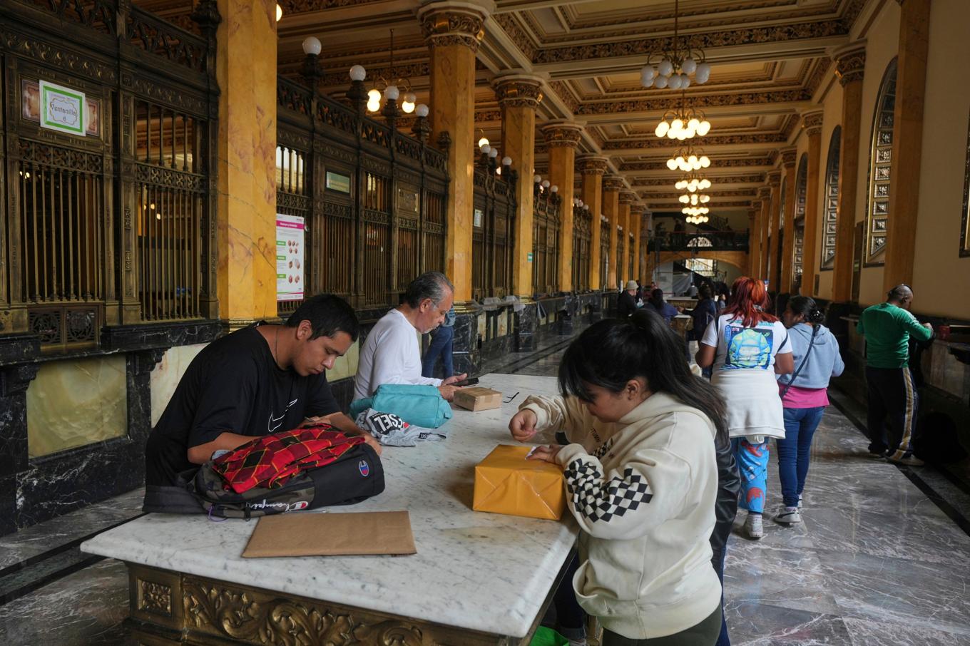 Människor förbereder paket som ska postas vid ett postkontor i Mexico City på onsdagen. Foto: Fernando Llano/AP/TT