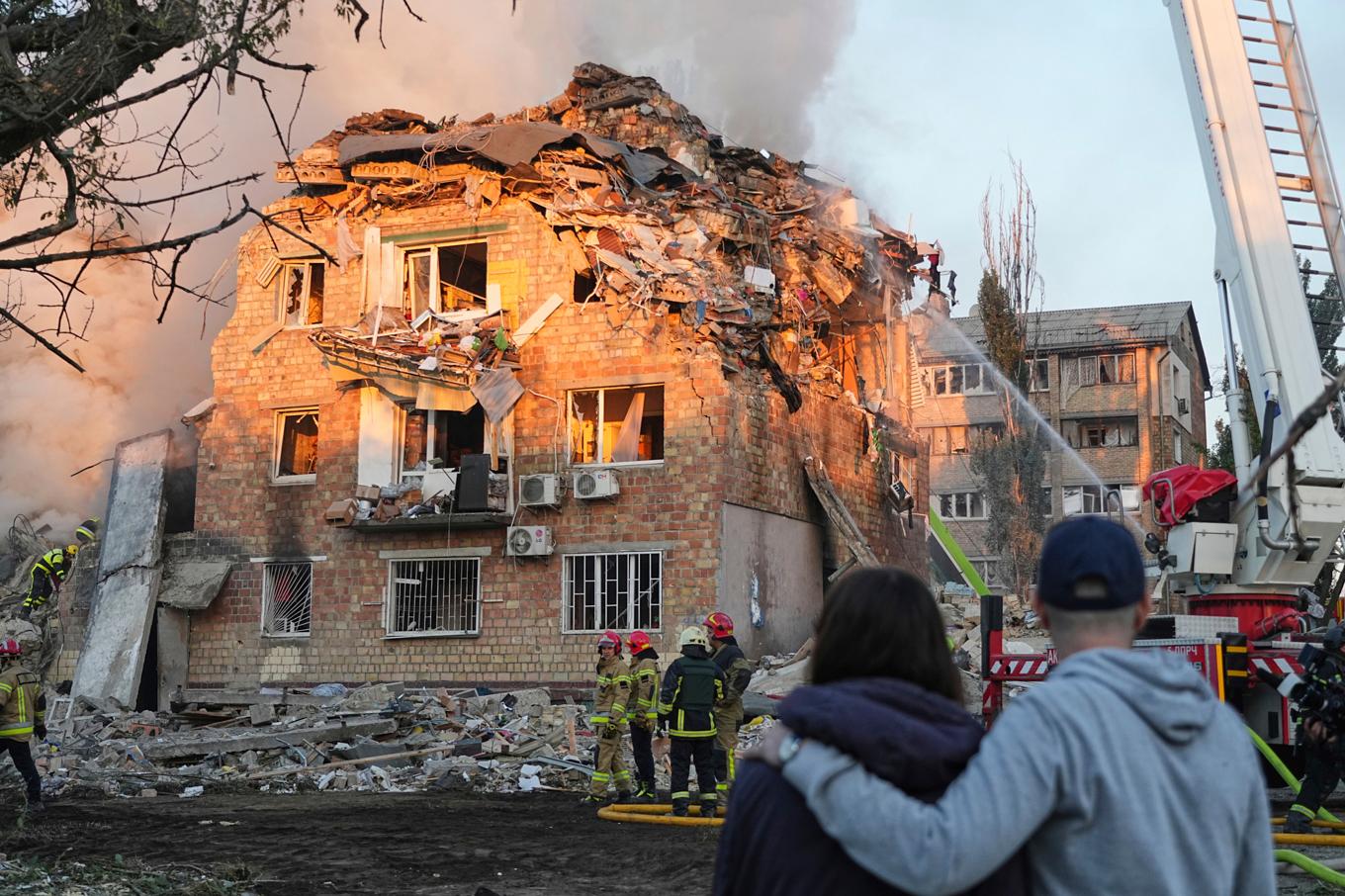 Räddningstjänsten försöker släcka en brand i en byggnad efter ryska attacker mot Ukrainas huvudstad Kiev under natten mot torsdagen. Foto: Efrem Lukatsky/AP/TT