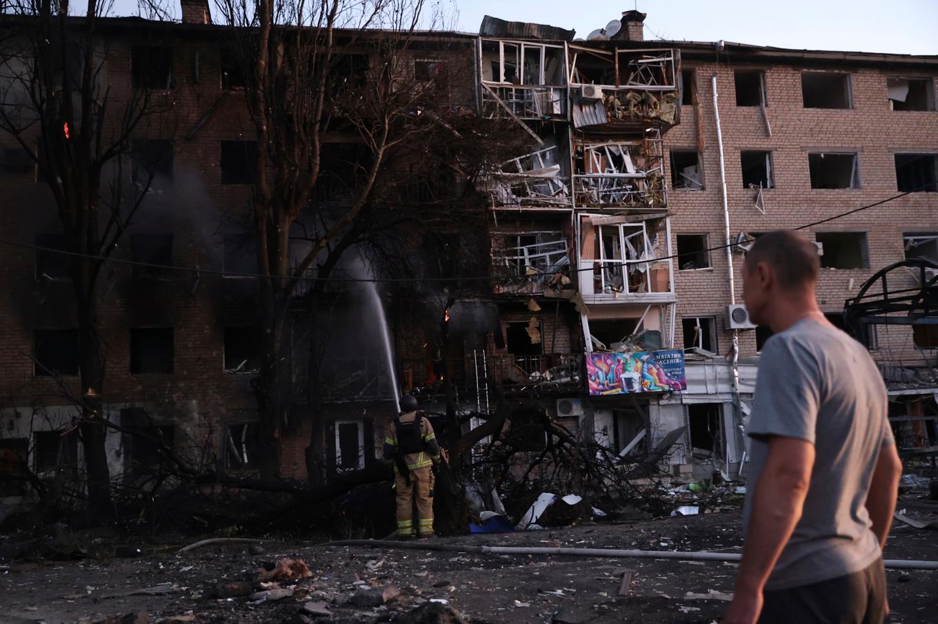 En Zaporizjzjabo framför sitt förstörda hem tidigt på lördagen, sedan Ryssland gått till attack under natten. Foto: Kateryna Klochko/AP/TT