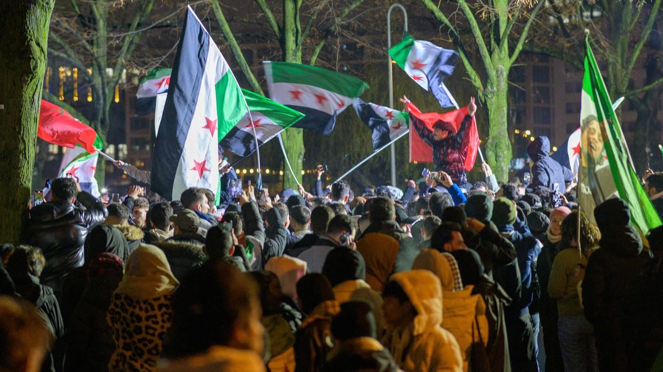 Människor viftar med den syriska oppositionens revolutionsflagga för att fira Bashar al-Assads och den syriska regimens fall under en demonstration i Berlin i Tyskland den 8 december 2024. Foto: Stefan Frank/Middle East Images/AFP via Getty Images