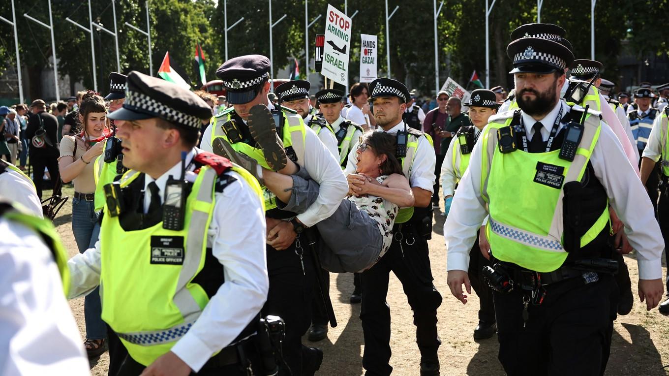 En demonstrant bärs bort av poliser i samband med protester som stödjer den förbjudna gruppen Palestine Action den 9 augusti i London. Foto: Henry Nicholls/AFP via Getty Images