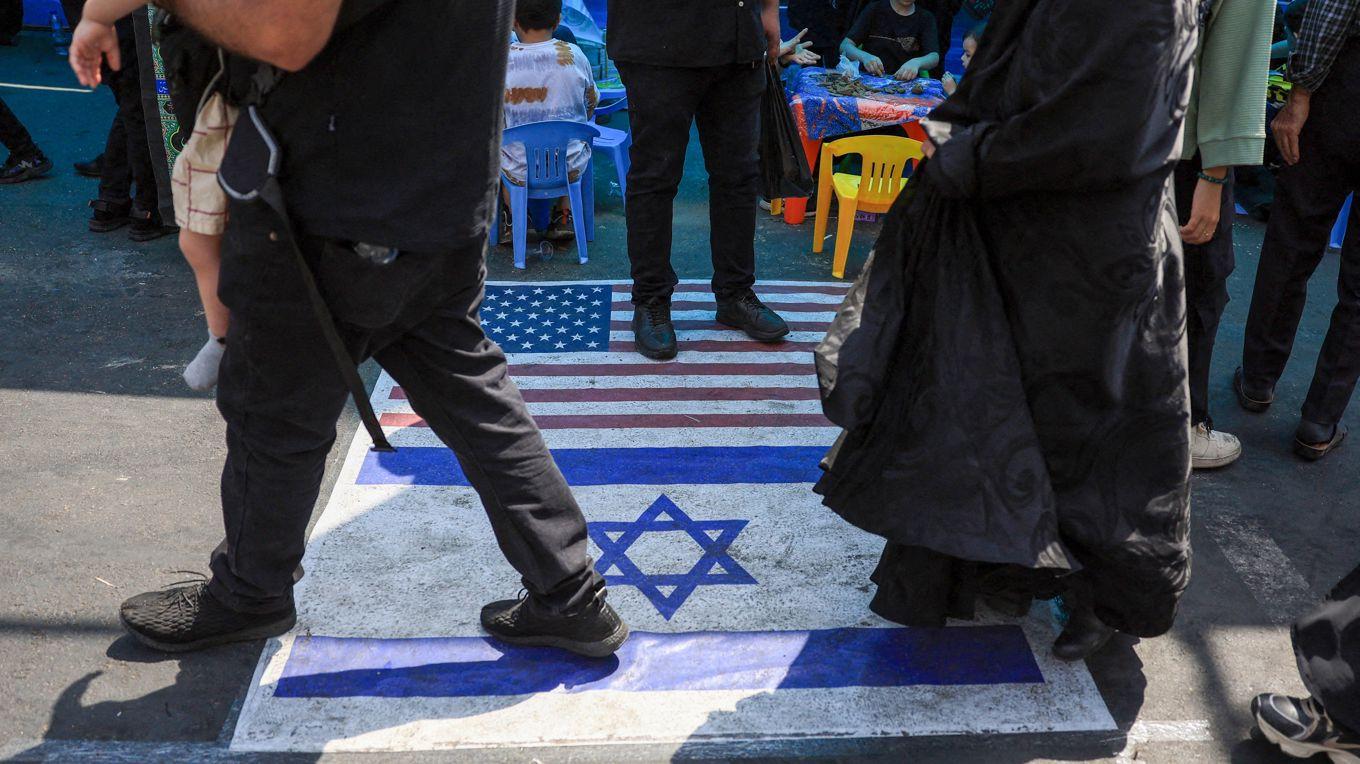 Bilden visar muslimer som går på amerikanska och israeliska flaggor på marken i Teheran den 14 augusti. Debattören menar att i de länder där islam har tagit över kontrollen leder det till att judar och kristna förföljs. Foto: AFP via Getty Images