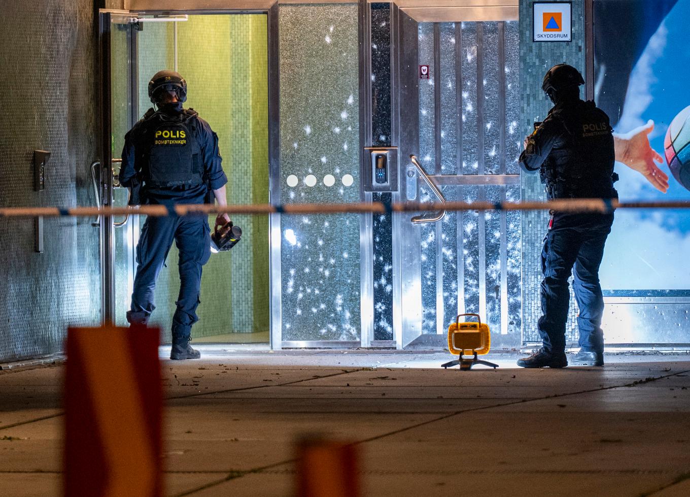 Bombtekniker undersöker splitterskador i en port i Malmö efter en explosion. Foto: Johan Nilsson/TT