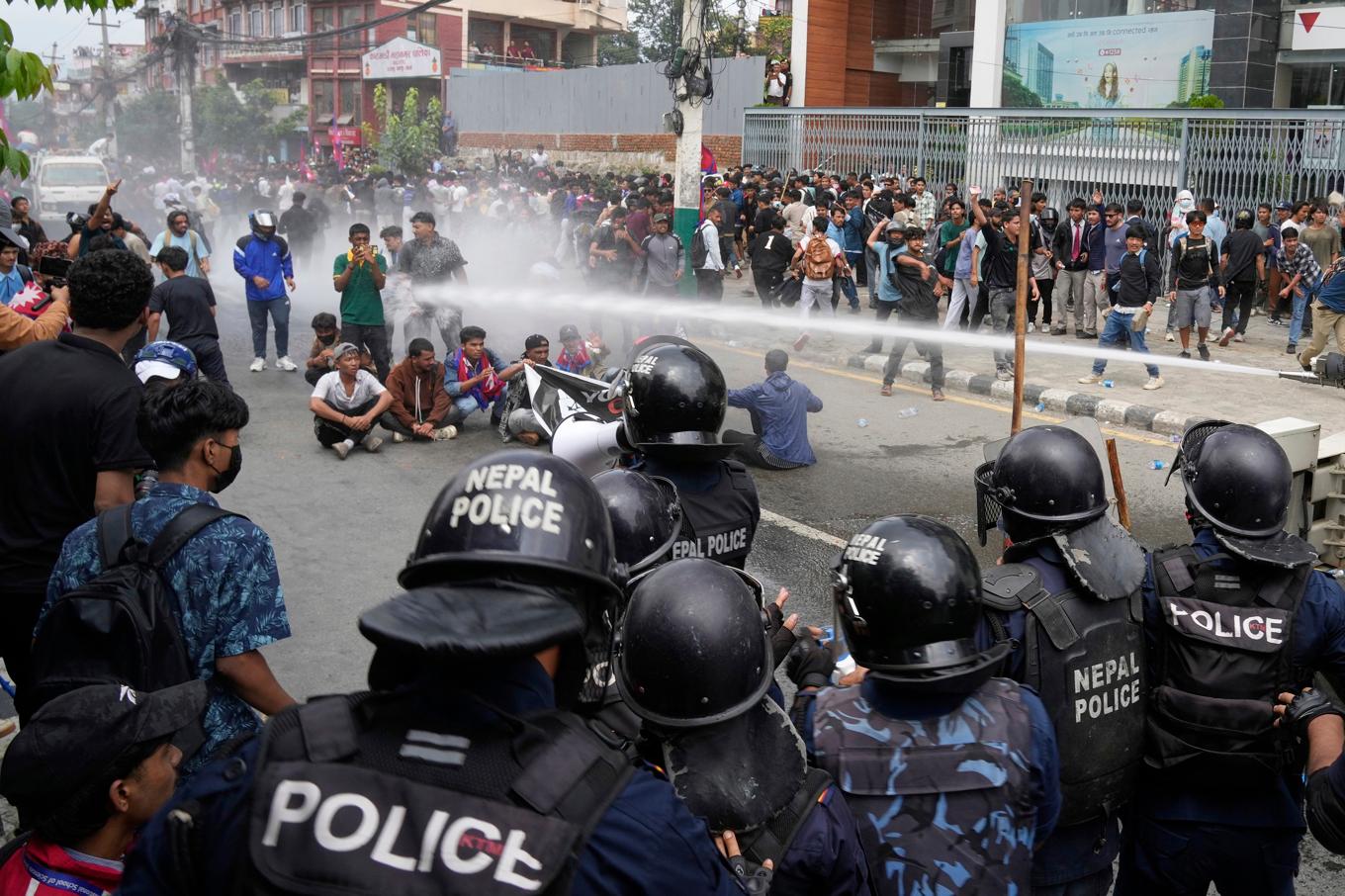 Kravallpolis använder vattenkanon mot demonstranter i Nepals huvudstad Katmandu. Foto: Niranjan Shrestha/AP/TT