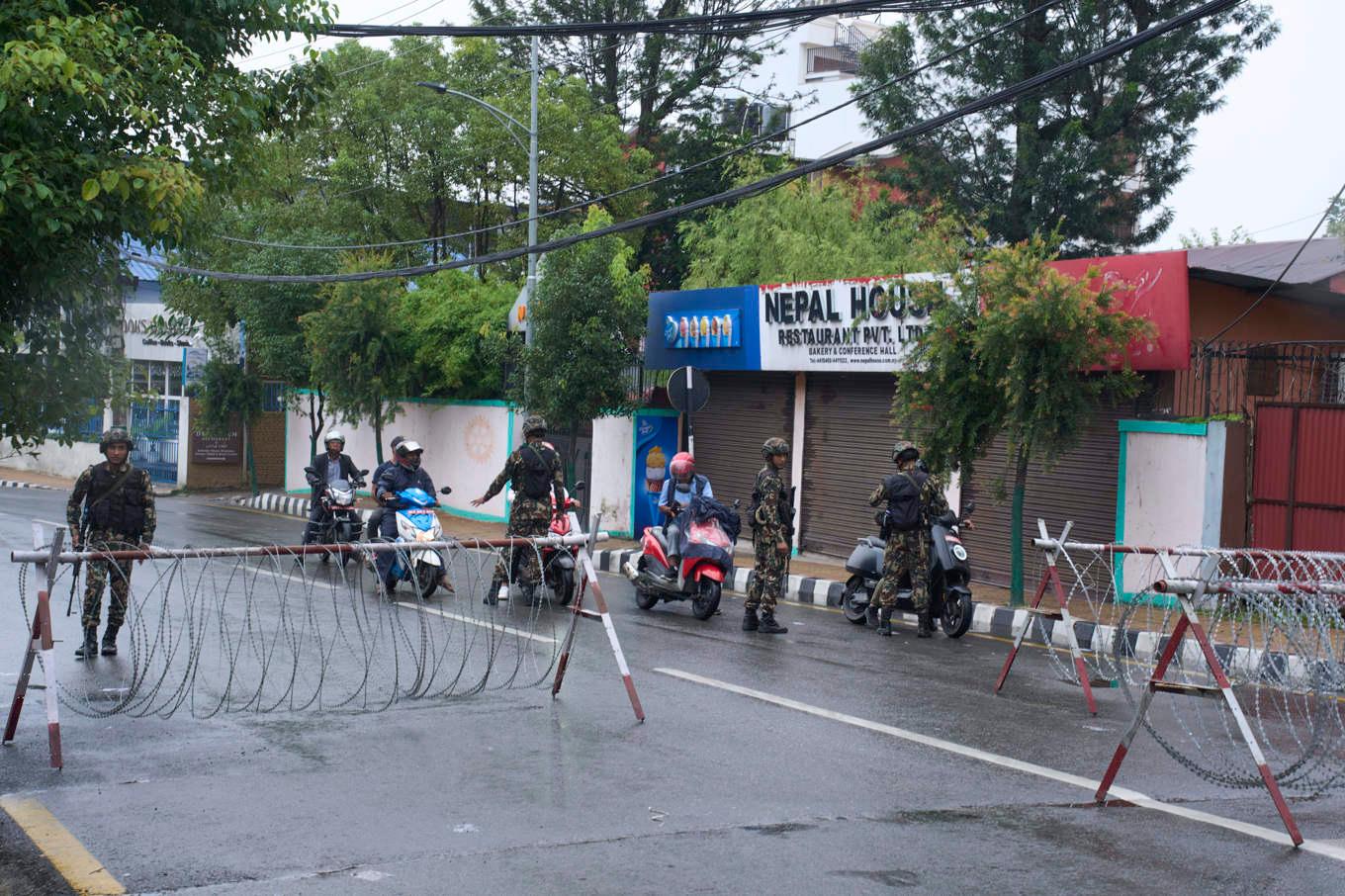 Nepalesisk militär utför personkontroller vid en vägspärr i Katmandu under onsdagen. Ett spänt lugn tycks råda i huvudstaden dagen efter kulmen på de våldsamma upploppen. Foto: Niranjan Shrestha/AP/TT