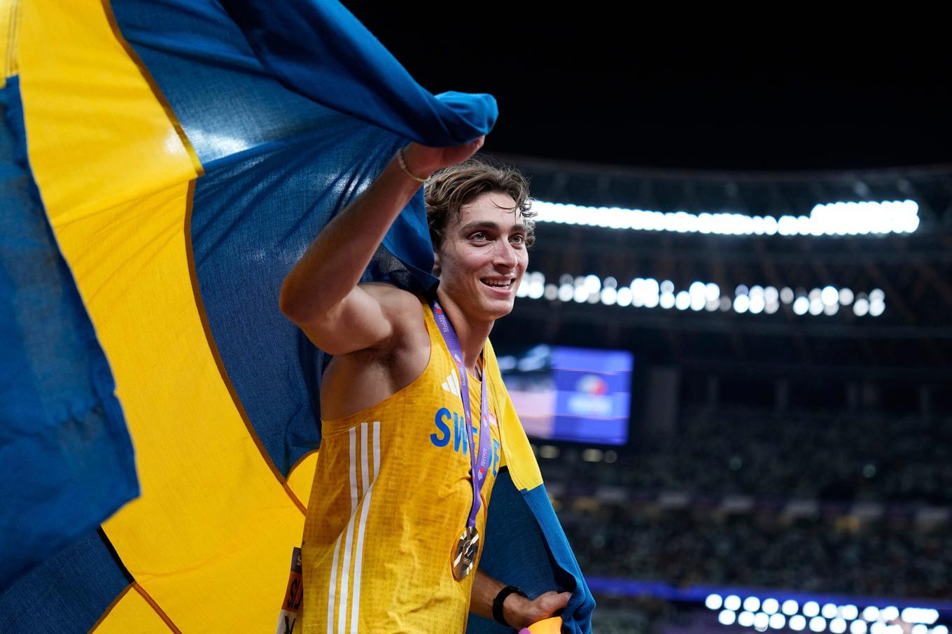 Armand Duplantis med svenska flaggan. Foto: Matthias Schrader/AP/TT