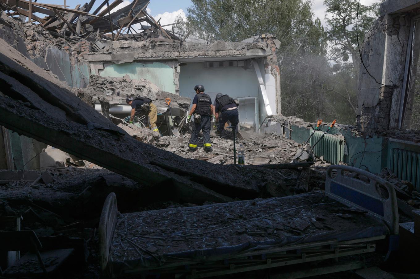 Räddningsarbetare går igenom rasmassorna i vad som är kvar av ett sjukhus i Charkiv efter ett ryskt flyganfall. Bilden tagen den 25 juli. Foto: Yevhen Titov/AP/TT