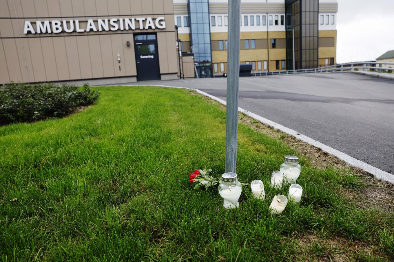 Blommor och ljus utanför ambulansstationen i Region Gävleborg i Hudiksvall, dagen efter att en ambulanssjukvårdare blivit dödad i tjänsten i Harmånger Nordanstig kommun. Foto: Mats Andersson/TT